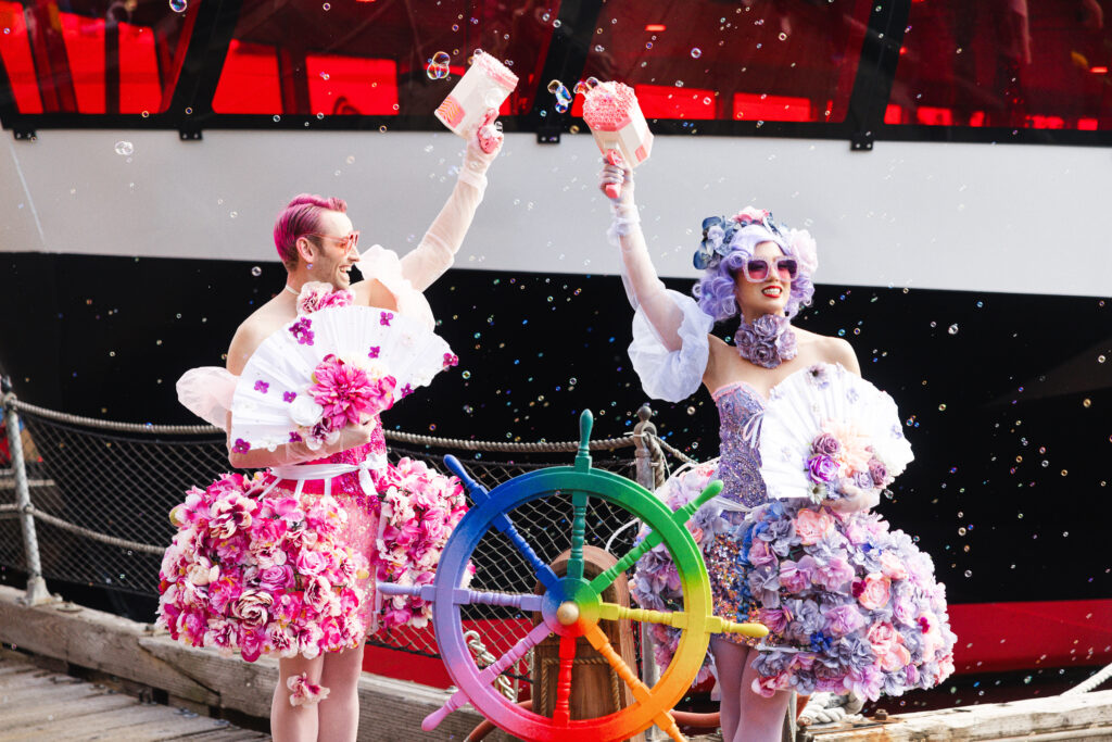 People in colorful costumes at a boat event.