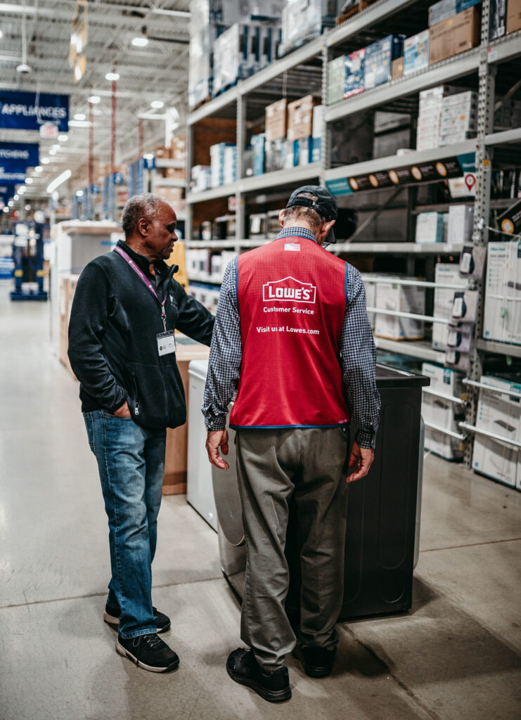 Lowe's associate helping a customer choose an appliance.